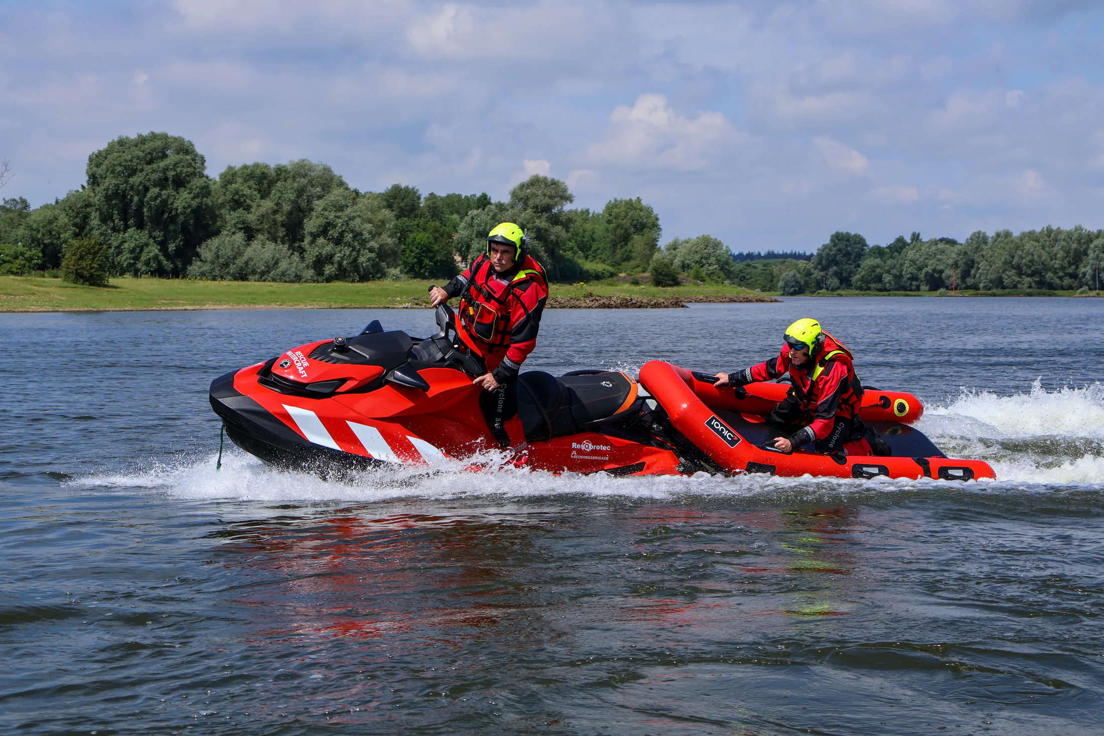 Twee redders op een reddingswaterscooter met Rescue Raft op het water