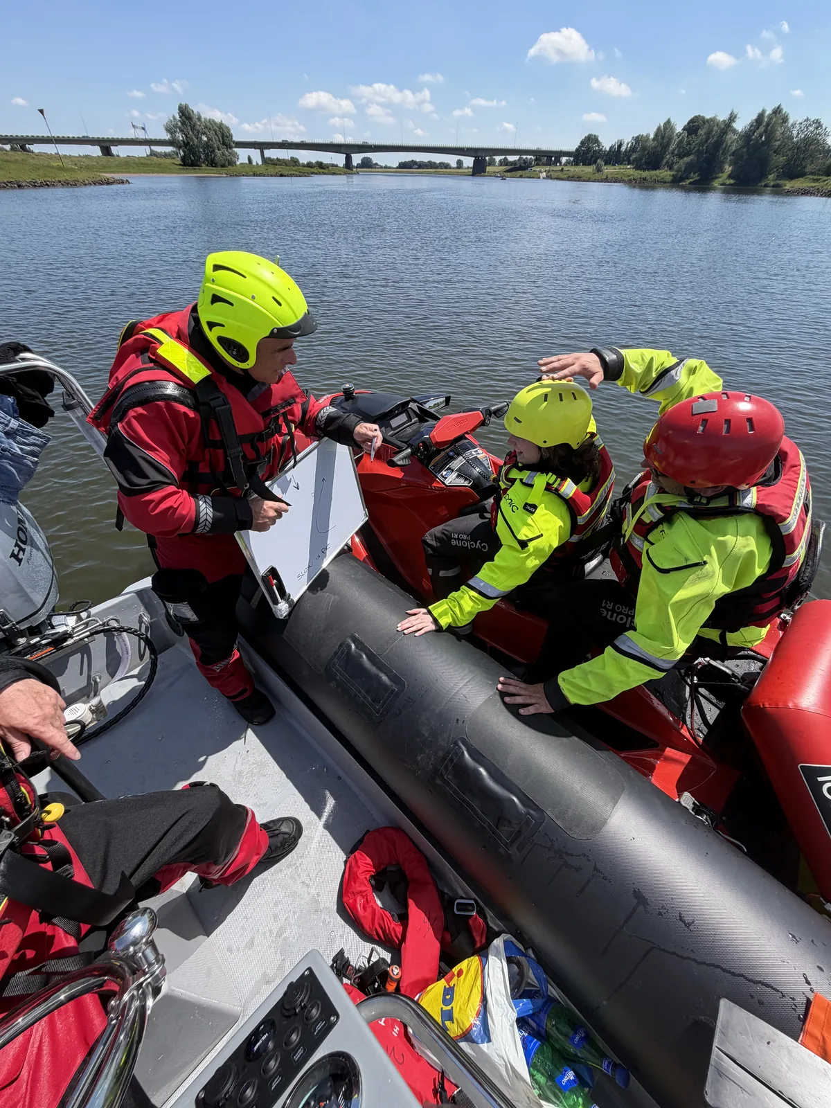 Instructeur geeft uitleg aan deelnemers bij een reddingswaterscooter